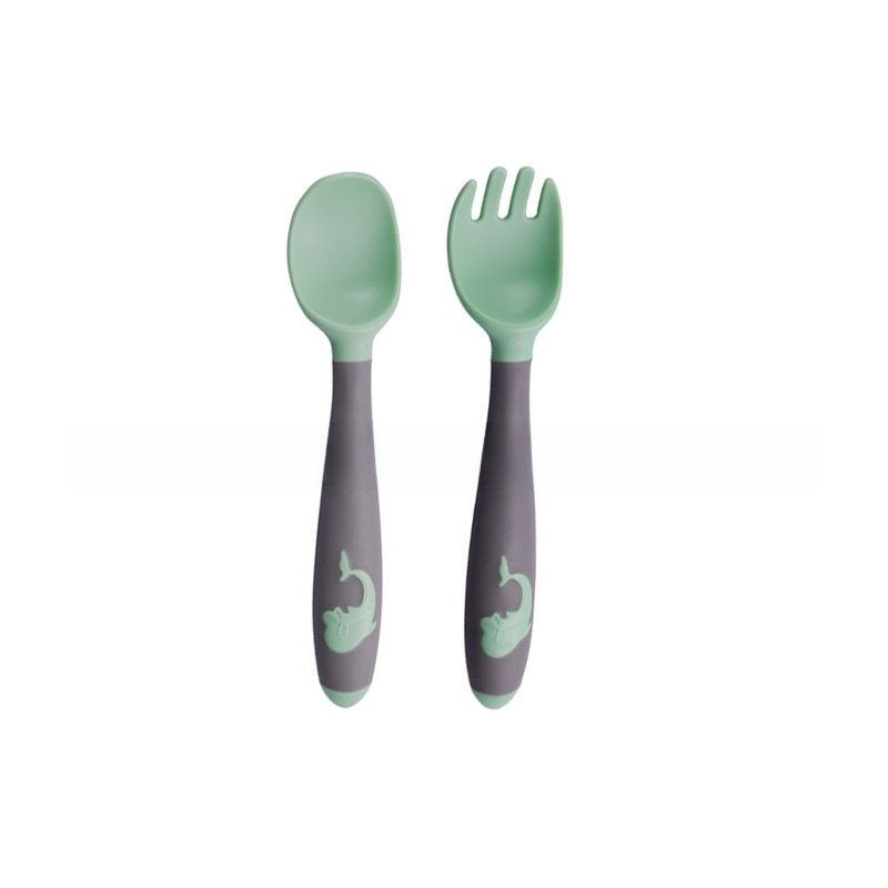 Baby learning to eat spoon and fork